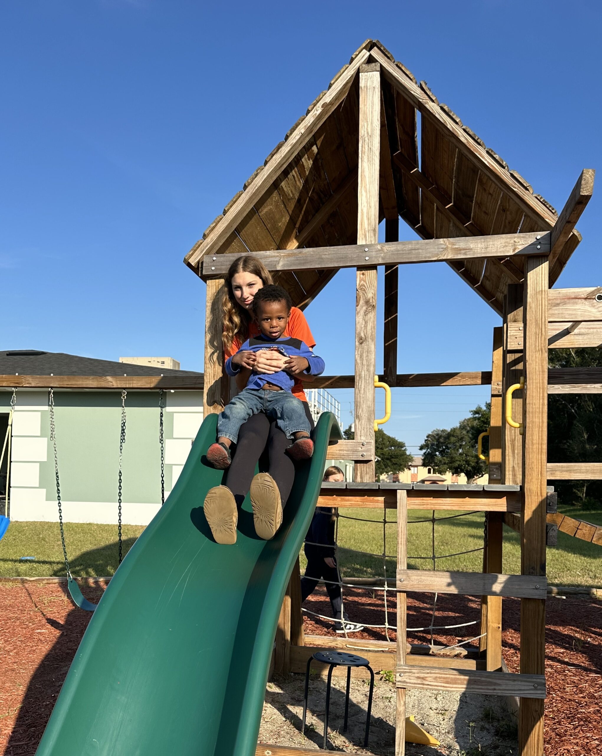 CITA Rescue Mission volunteer spending time with a child at the family shelter playground in Melbourne, Florida