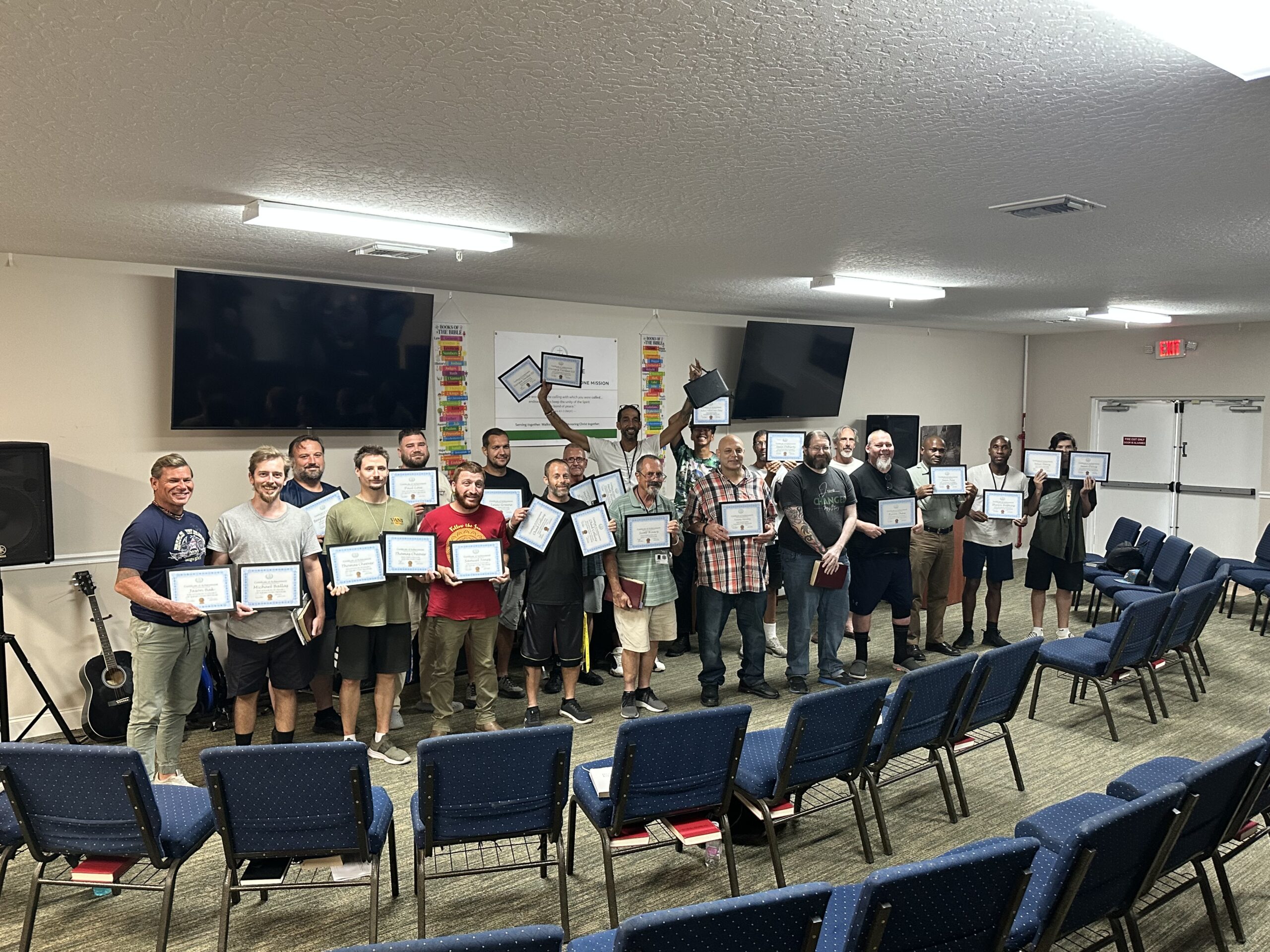 Men at Christ Is The Answer Rescue Mission celebrating program progress and graduation milestones