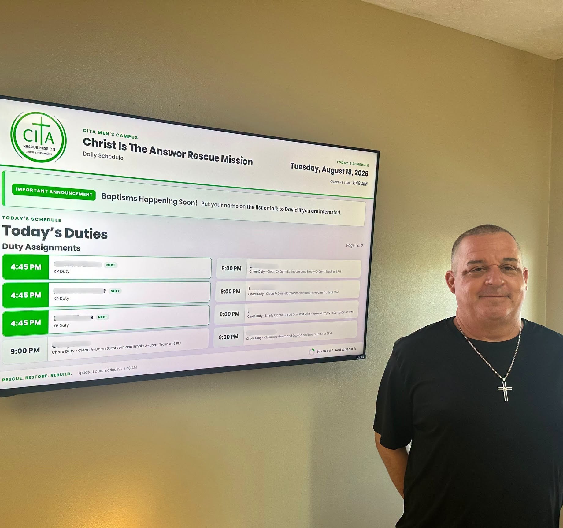 CITA graduate Tony Banks beside the digital schedule television he donated